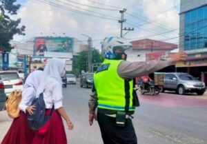 Wujud Kepedulian, Polisi Bantu Anak Sekolah Menyeberang Jalan